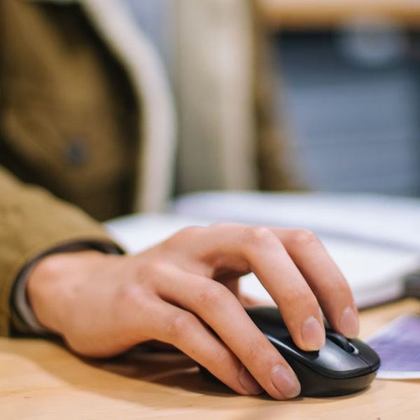 Close up picture of someone's hand on a computer mouse.